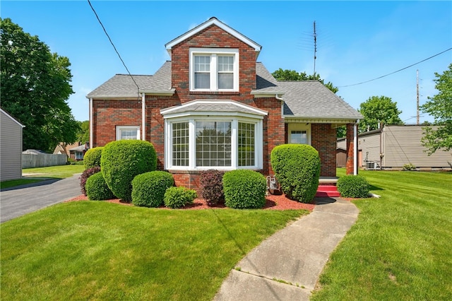 300 W Elizabeth St, Neshannock Twp, PA 16105 - view of front of property featuring brick siding, a front lawn, roof with shingles, and cooling unit