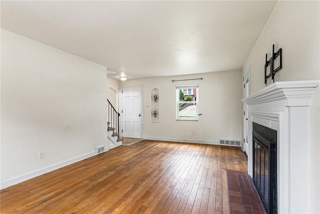 51 Hollow Haven Dr, Baldwin Boro, PA 15236 - unfurnished living room featuring a tile fireplace, stairway, light wood-style floors, and baseboards