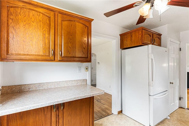 51 Hollow Haven Dr, Baldwin Boro, PA 15236 - kitchen featuring freestanding refrigerator, a ceiling fan, brown cabinetry, and light countertops