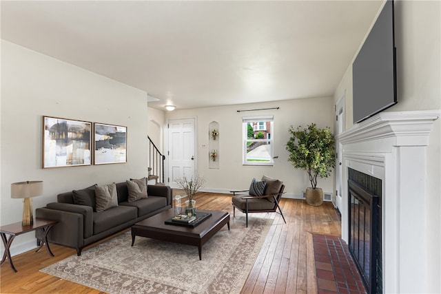 51 Hollow Haven Dr, Baldwin Boro, PA 15236 - living area featuring a tiled fireplace, stairway, light wood-style floors, and baseboards