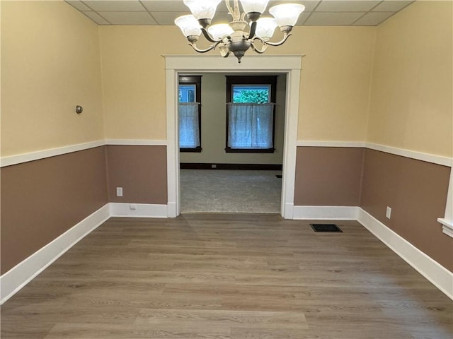 243 Oak St, City Of But Ne, PA 16001 - unfurnished dining area featuring a drop ceiling, a chandelier, baseboards, and wood finished floors