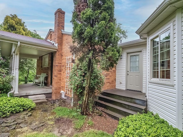 305 Ivy Dr, Pine Twp Nal, PA 15044 - view of exterior entry featuring brick siding, metal roof, and a chimney