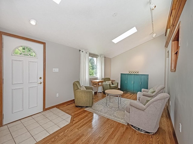 305 Ivy Dr, Pine Twp Nal, PA 15044 - living area with vaulted ceiling, light wood finished floors, a skylight, and baseboards