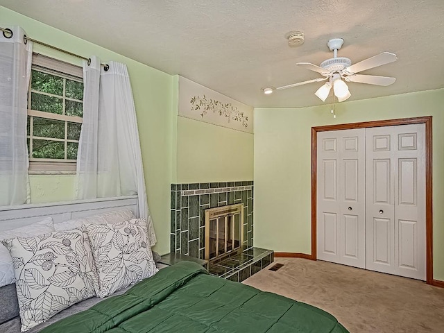305 Ivy Dr, Pine Twp Nal, PA 15044 - carpeted bedroom featuring a tiled fireplace, baseboards, a closet, a ceiling fan, and a textured ceiling
