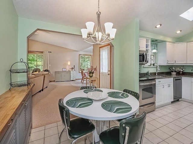 305 Ivy Dr, Pine Twp Nal, PA 15044 - kitchen with stainless steel appliances, a sink, vaulted ceiling, light tile patterned flooring, and white cabinetry