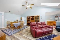 1011 Sunnyfield Ct, Penn Twp Wml, PA 15636 - living area with lofted ceiling, wood finished floors, a ceiling fan, and a skylight