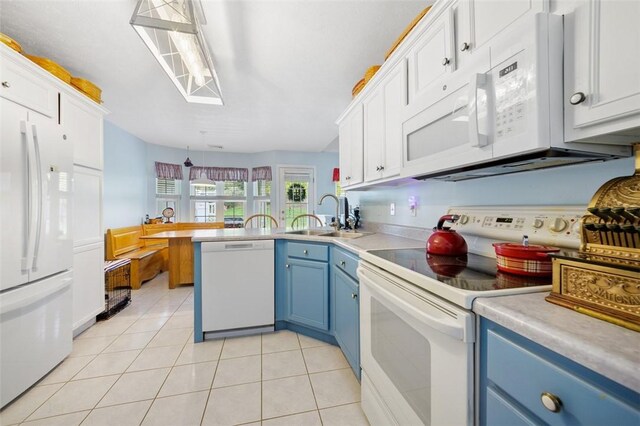 1011 Sunnyfield Ct, Penn Twp Wml, PA 15636 - kitchen with blue cabinetry, white appliances, a sink, a peninsula, and light countertops