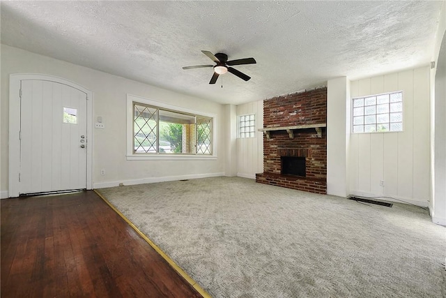 163 Universal Rd, Penn Hills, PA 15235 - unfurnished living room featuring a textured ceiling, ceiling fan, healthy amount of natural light, wood-type flooring, and baseboards