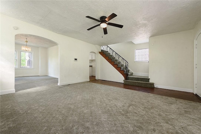163 Universal Rd, Penn Hills, PA 15235 - unfurnished living room with arched walkways, carpet floors, ceiling fan, a textured ceiling, and plenty of natural light