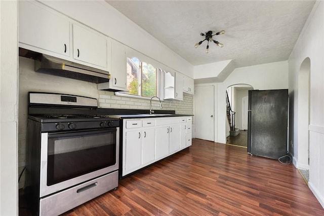 163 Universal Rd, Penn Hills, PA 15235 - kitchen with stainless steel gas range, freestanding refrigerator, dark countertops, and arched walkways