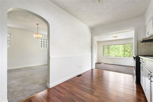 163 Universal Rd, Penn Hills, PA 15235 - kitchen featuring a textured ceiling, arched walkways, white cabinets, dark wood finished floors, and a chandelier