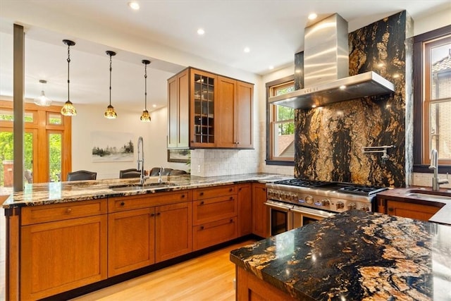 3319 Beechwood Blvd, Squirrel Hill, PA 15217 - kitchen featuring wall chimney exhaust hood, a sink, range with two ovens, brown cabinetry, and a peninsula