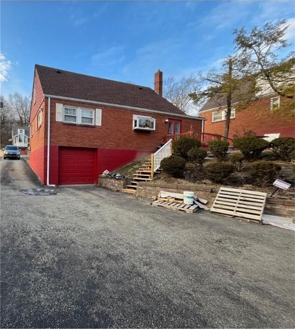 5 Barton Dr, Churchill Boro, PA 15221 - view of home's exterior featuring an attached garage, a chimney, driveway, and stairway