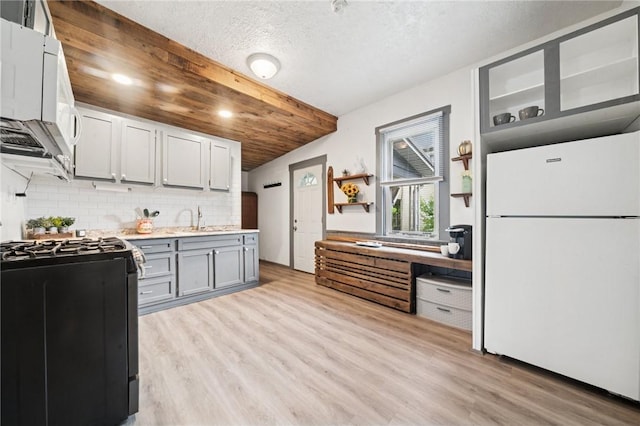507 Sells Ln, Hempfield Twp Wml, PA 15601 - kitchen featuring white appliances, light wood-type flooring, tasteful backsplash, light countertops, and a textured ceiling