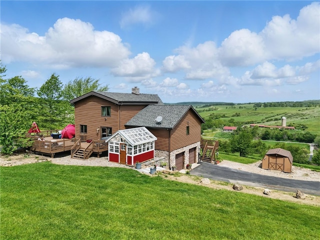 395 Lynn Portal Rd, Mount Pleasant Twp Was, PA 15301 - rear view of house with a wooden deck, stone siding, driveway, a shingled roof, and a yard