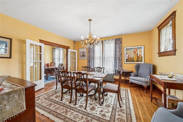 301 W Patriot St, Somerset Boro, PA 15501 - dining area with healthy amount of natural light, a chandelier, radiator heating unit, and wood finished floors