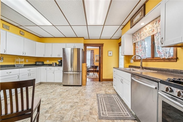 301 W Patriot St, Somerset Boro, PA 15501 - kitchen with stainless steel appliances, a drop ceiling, a sink, white cabinets, and dark countertops