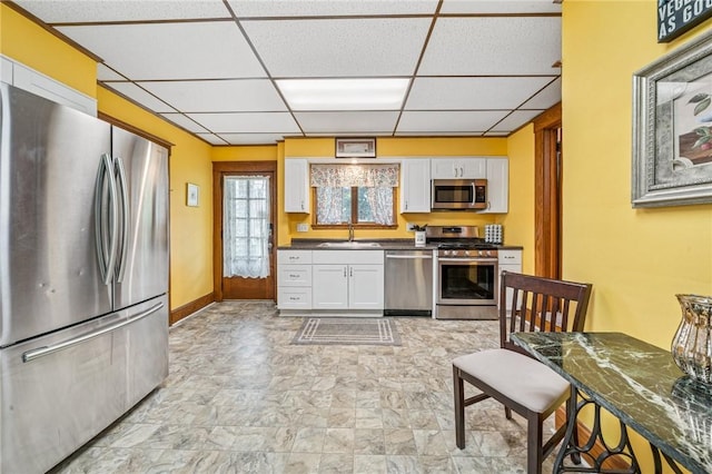 301 W Patriot St, Somerset Boro, PA 15501 - kitchen with appliances with stainless steel finishes, a sink, a paneled ceiling, white cabinetry, and dark countertops