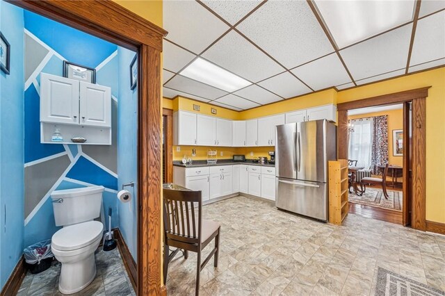 301 W Patriot St, Somerset Boro, PA 15501 - kitchen with freestanding refrigerator, baseboards, a drop ceiling, white cabinets, and dark countertops