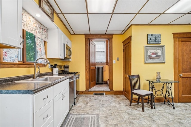 301 W Patriot St, Somerset Boro, PA 15501 - kitchen featuring stainless steel appliances, radiator heating unit, a sink, dark countertops, and white cabinetry