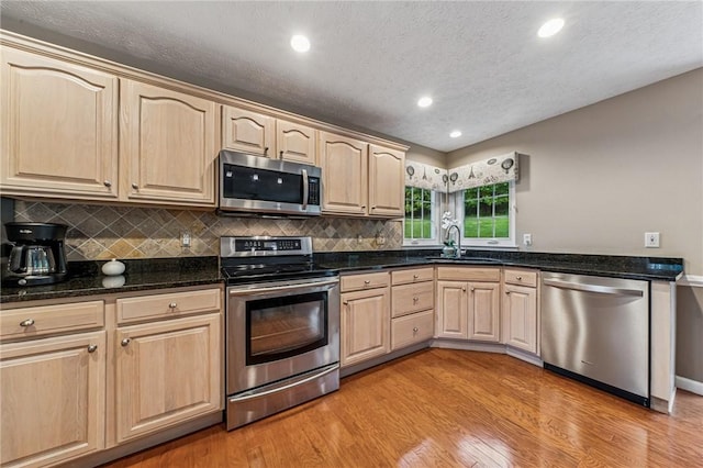 8201 Club Side Dr, Adams Twp, PA 16046 - kitchen featuring appliances with stainless steel finishes, a sink, light brown cabinetry, light wood-type flooring, and tasteful backsplash