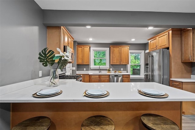 273 Inglewood Dr, Mt Lebanon, PA 15228 - kitchen with appliances with stainless steel finishes, a sink, a peninsula, light countertops, and a breakfast bar