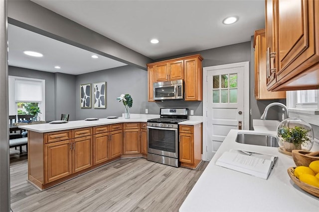 273 Inglewood Dr, Mt Lebanon, PA 15228 - kitchen with stainless steel appliances, a sink, light countertops, light wood-style flooring, and a peninsula