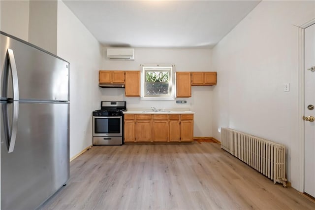 636 Edmond St, Bloomfield, PA 15224 - kitchen with appliances with stainless steel finishes, radiator heating unit, a wall mounted AC, a sink, and light countertops