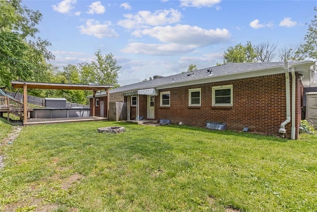 108 W Rd, Shaler, PA 15209 - back of property featuring an outdoor fire pit, a deck, brick siding, and a yard