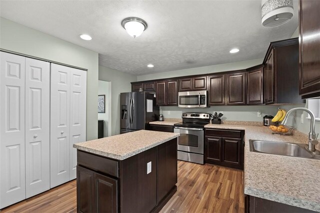 1033 Granite Dr, South Fayette, PA 15057 - kitchen with appliances with stainless steel finishes, a sink, dark brown cabinetry, light countertops, and light wood finished floors