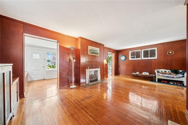 7333 Mcclure Ave, Swissvale, PA 15218 - unfurnished living room featuring a fireplace, wooden walls, and wood finished floors