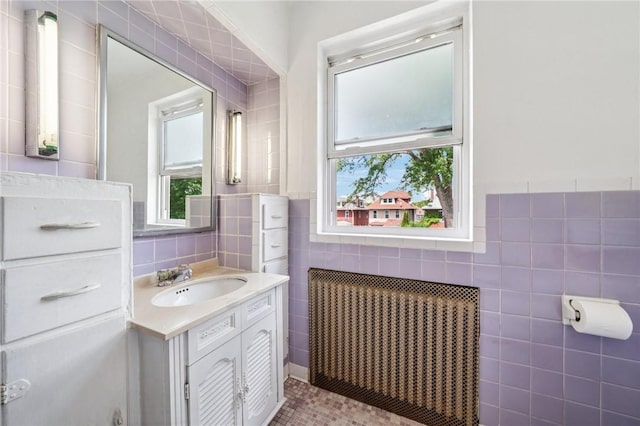 7333 Mcclure Ave, Swissvale, PA 15218 - bathroom with radiator heating unit, tile walls, vanity, and tile patterned floors