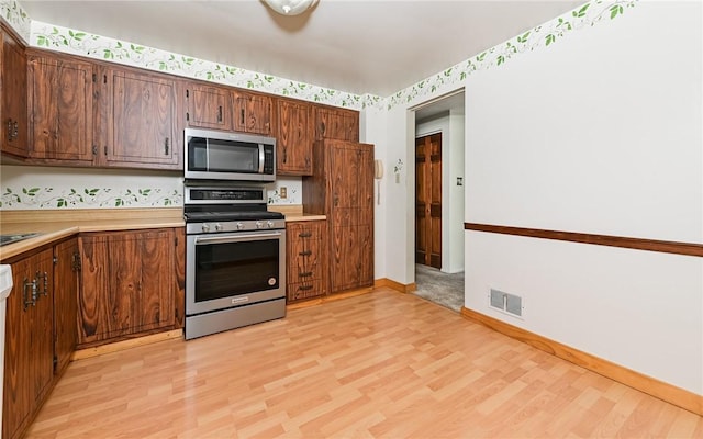 4610 School Dr, Hampton, PA 15101 - kitchen featuring stainless steel appliances, light wood-type flooring, light countertops, baseboards, and wallpapered walls