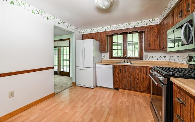 4610 School Dr, Hampton, PA 15101 - kitchen with stainless steel appliances, a sink, light wood-style flooring, light countertops, and baseboards