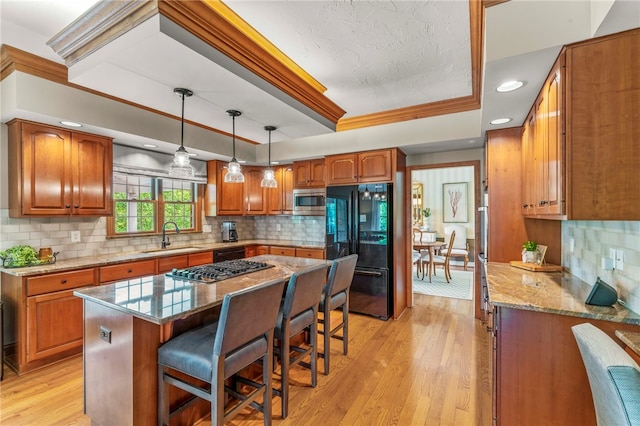 105 Pin Oak Ct, Peters Twp, PA 15367 - kitchen featuring stainless steel appliances, a sink, brown cabinets, a tray ceiling, and recessed lighting
