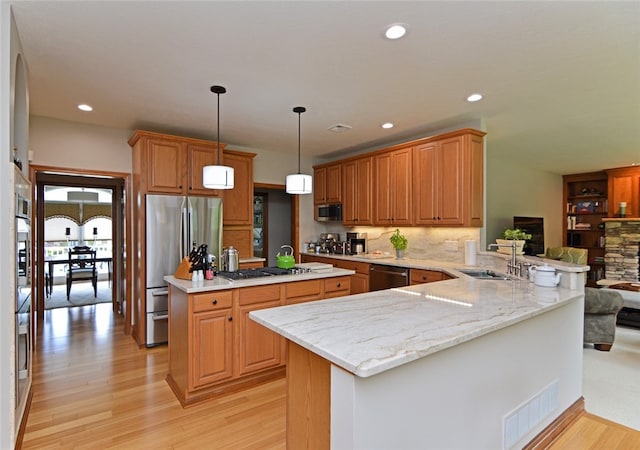 3875 Ashland Ct, Hampton, PA 15101 - kitchen featuring appliances with stainless steel finishes, a sink, light wood-type flooring, a peninsula, and decorative backsplash