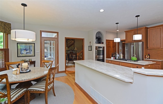 3875 Ashland Ct, Hampton, PA 15101 - kitchen featuring stainless steel appliances, a center island, light wood-style floors, brown cabinets, and recessed lighting
