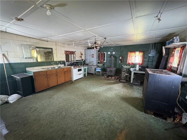 23682 Rte 949, Ridgway, PA 15853 - kitchen featuring a wood stove, gas range gas stove, concrete block wall, brown cabinetry, and a sink