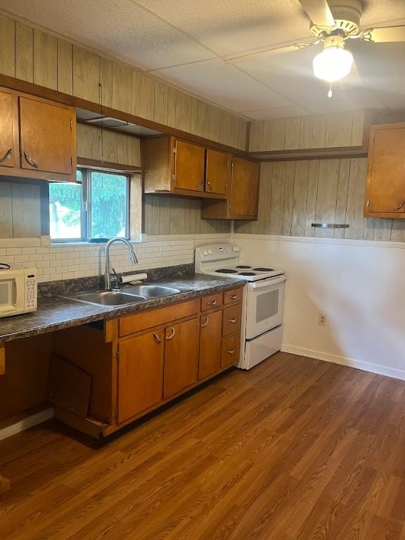 116 Third St, West Bethlehem, PA 15368 - kitchen featuring white appliances, a sink, brown cabinetry, dark countertops, and decorative backsplash