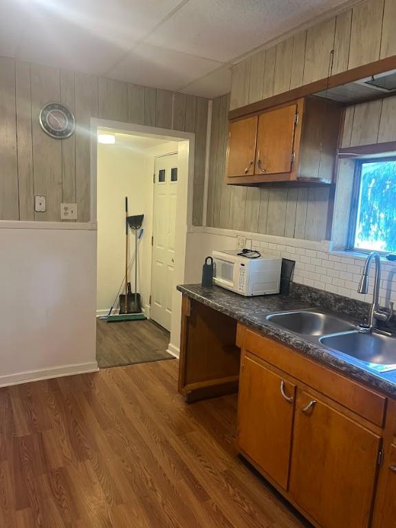 116 Third St, West Bethlehem, PA 15368 - kitchen with white microwave, a sink, brown cabinetry, dark countertops, and dark wood-style floors