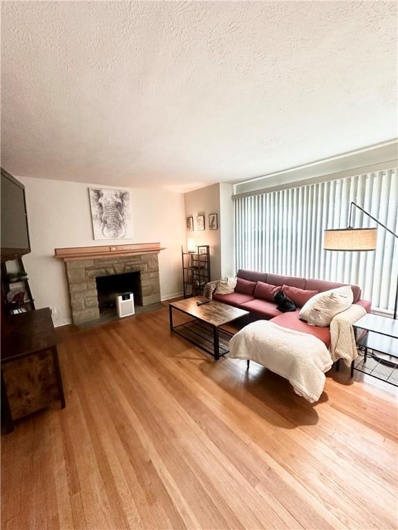 1425 Elgin, Aliquippa, PA 15001 - living room featuring a textured ceiling, wood finished floors, and a stone fireplace