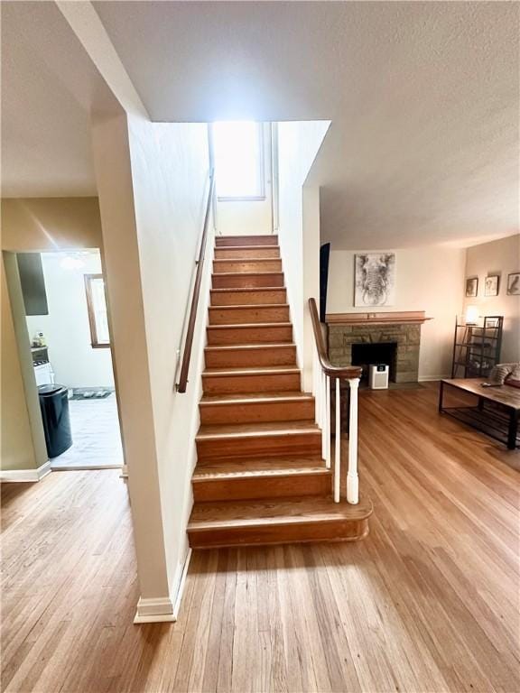 1425 Elgin, Aliquippa, PA 15001 - stairway with wood finished floors, a stone fireplace, and baseboards