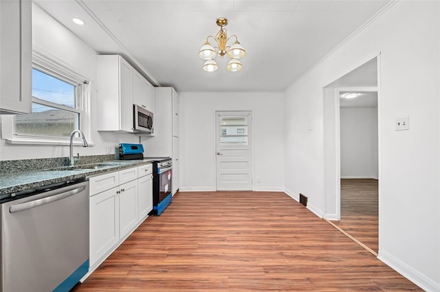 425 Routh Dr, Monroeville, PA 15146 - kitchen featuring appliances with stainless steel finishes, a sink, dark stone countertops, a chandelier, and wood finished floors