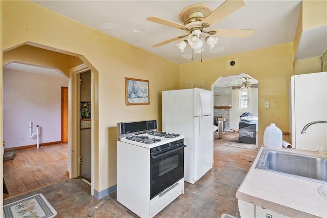 828 Georgia Ave, Bon Air, PA 15210 - kitchen featuring white appliances, ceiling fan, a sink, arched walkways, and light countertops
