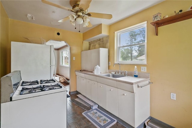 828 Georgia Ave, Bon Air, PA 15210 - kitchen featuring a sink, white gas stove, a ceiling fan, light countertops, and white cabinetry
