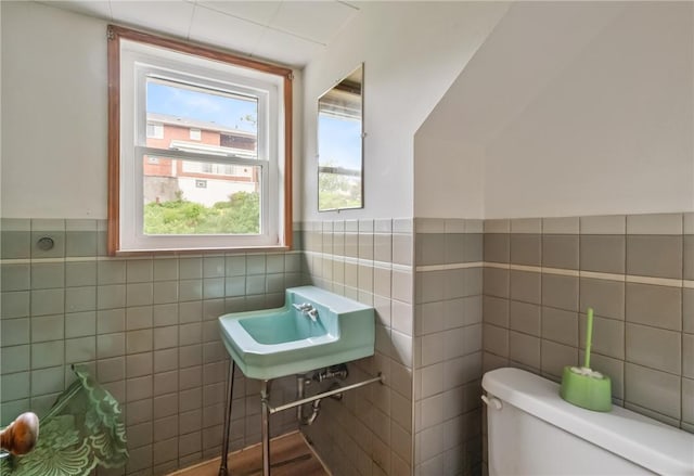 828 Georgia Ave, Bon Air, PA 15210 - half bathroom with tile walls, toilet, a sink, and a wainscoted wall