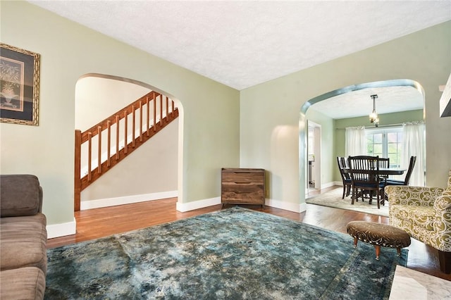 1521 Claim St, Troy Hill, PA 15212 - living area featuring wood finished floors, arched walkways, and stairway