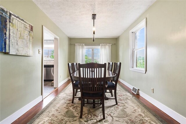 1521 Claim St, Troy Hill, PA 15212 - dining space featuring wood finished floors, a textured ceiling, and baseboards
