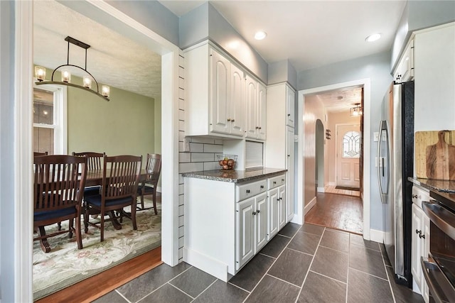 1521 Claim St, Troy Hill, PA 15212 - kitchen with freestanding refrigerator, stove, arched walkways, and white cabinets