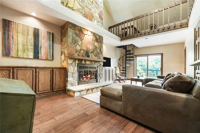 1521 Claim St, Troy Hill, PA 15212 - living area with a high ceiling, stairs, a fireplace, light wood-style floors, and recessed lighting